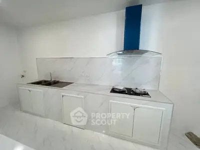 Modern kitchen with sleek white cabinetry and gas stove