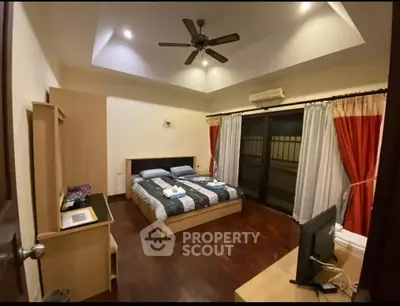 Spacious bedroom with modern furnishings and large windows for natural light.