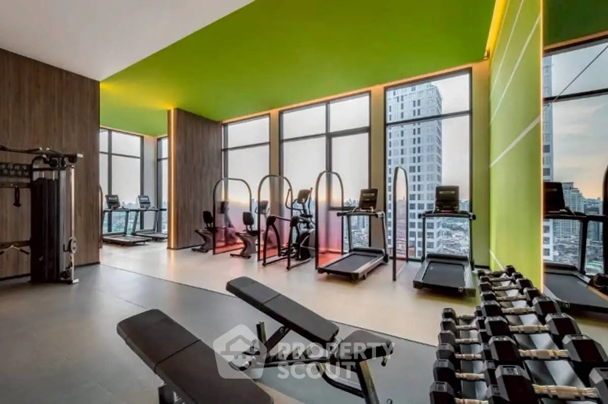 Modern gym with city view and state-of-the-art equipment in luxury high-rise building.
