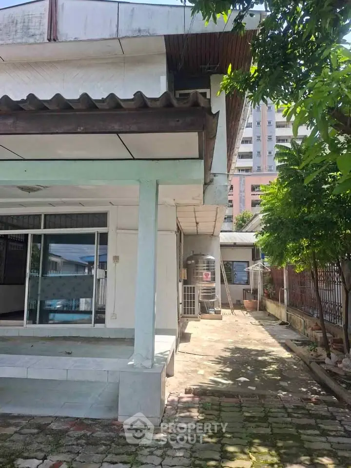 Charming residential property with spacious outdoor area and lush greenery, perfect for family living.