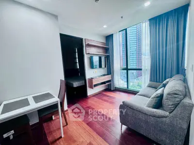 Modern living room with hardwood floors and large window view in urban apartment.