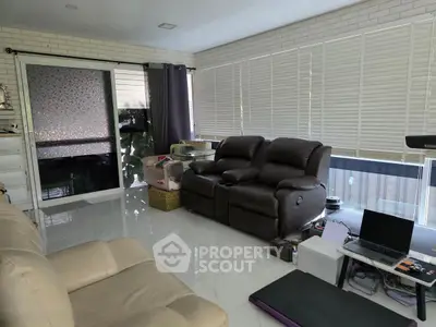 Spacious living room with modern leather sofas and large windows