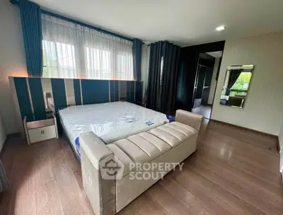 Spacious modern bedroom with elegant decor and large windows for natural light.