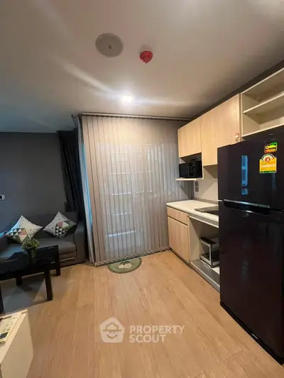 Modern living room with kitchenette and stylish decor in a cozy apartment setting.