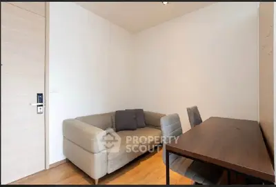 Cozy living room with modern sofa and dining table, perfect for small gatherings.