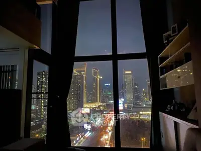 Stunning cityscape view from a modern high-rise apartment window at night, showcasing vibrant urban lights.