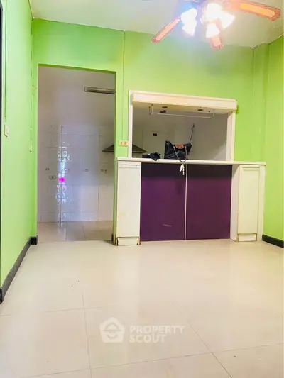 Spacious open layout with vibrant green walls and ceiling fan