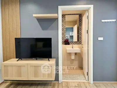 Modern living room with TV and stylish bathroom entrance