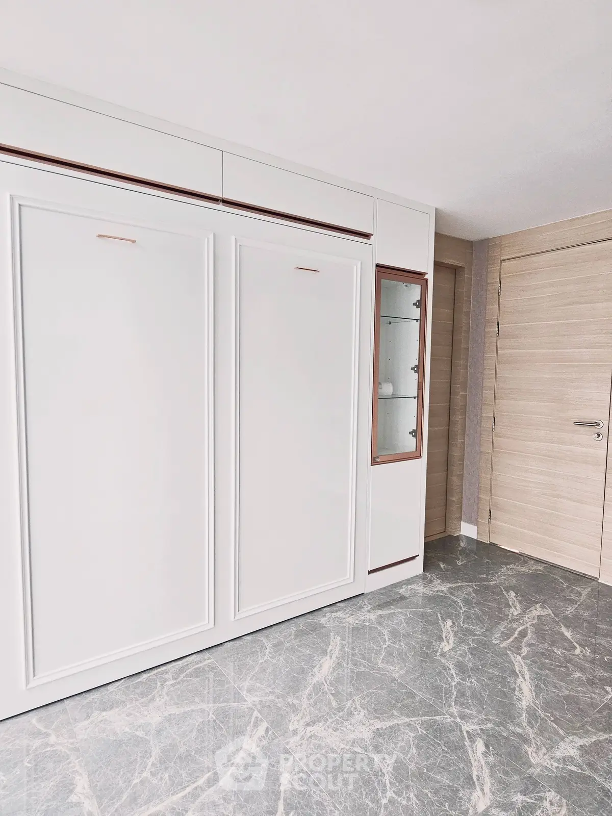 Modern interior with sleek cabinetry and marble flooring in a stylish apartment.