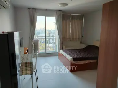 Modern bedroom with city view, featuring a cozy bed, desk, and large window for natural light.