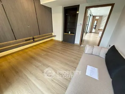 Spacious modern living room with wooden flooring and stylish built-in shelving.