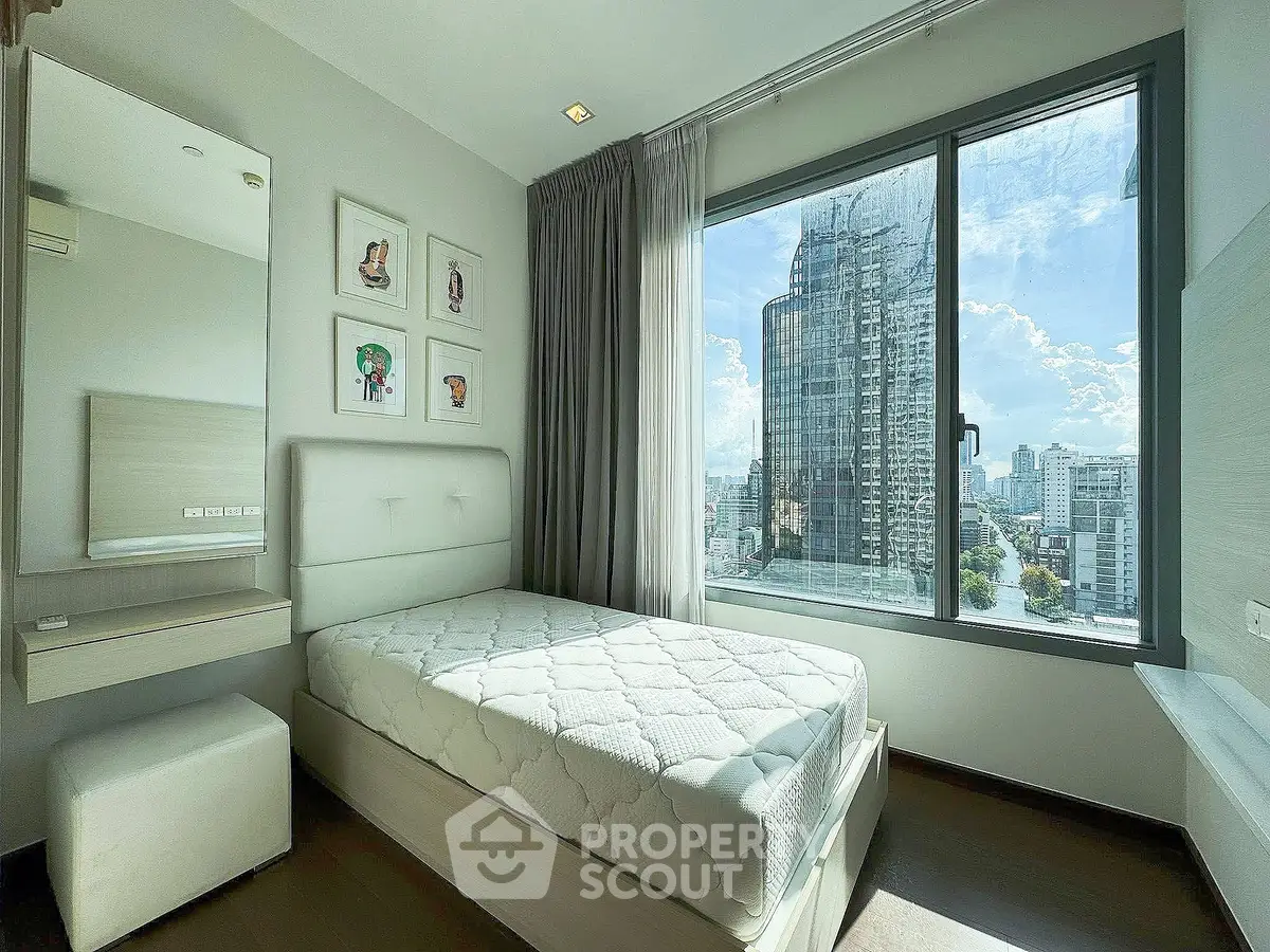 Modern bedroom with large window offering stunning city view in high-rise apartment