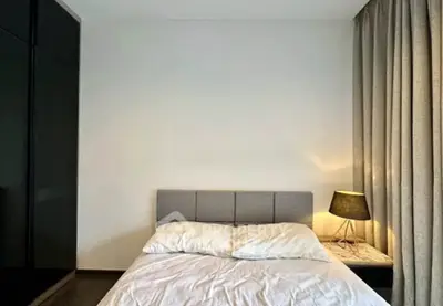 Modern bedroom with cozy lighting and elegant curtains, perfect for relaxation.