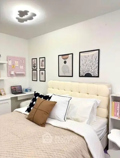 Cozy bedroom with stylish decor and modern artwork on walls.