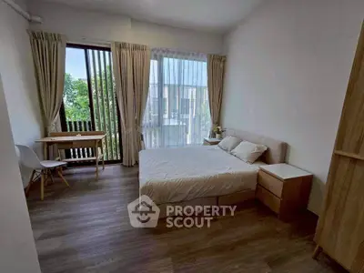 Spacious bedroom with large window and modern furnishings