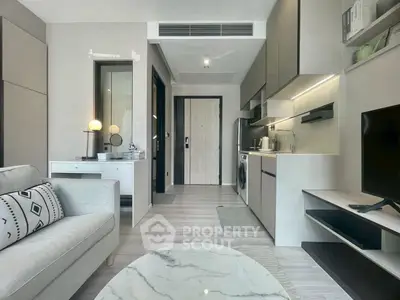 Modern living room with sleek kitchen and stylish decor in a contemporary apartment.