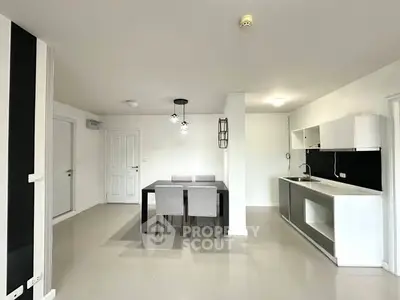 Modern open-plan kitchen and dining area with sleek design and neutral tones.