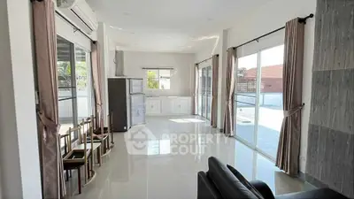 Spacious living room with large windows and modern furnishings in a bright, airy home.