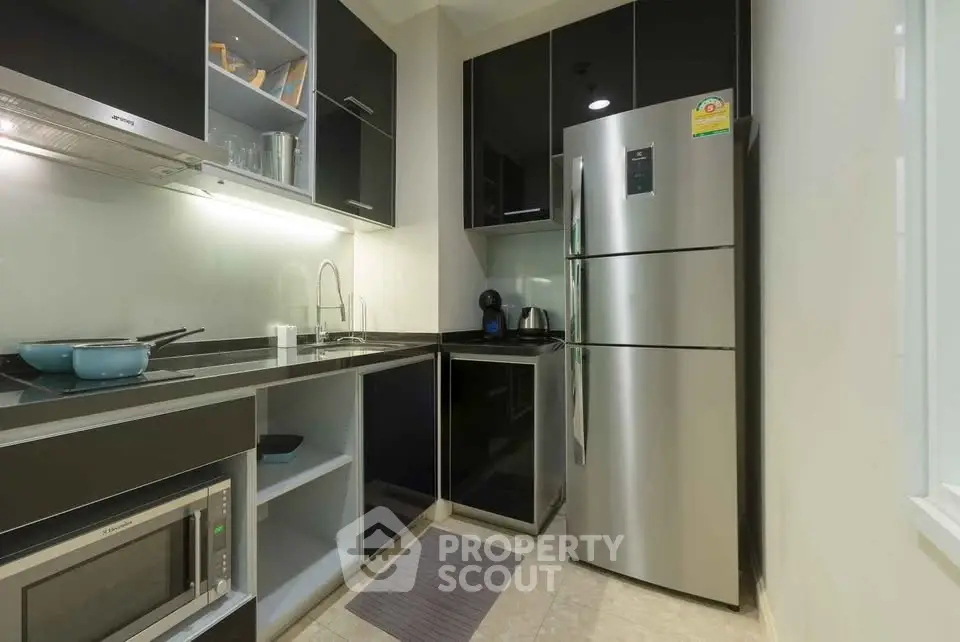Modern kitchen with sleek black cabinets and stainless steel appliances