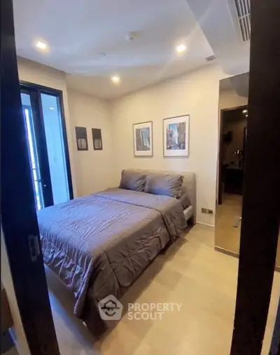 Cozy bedroom with modern decor and balcony access in a stylish apartment.