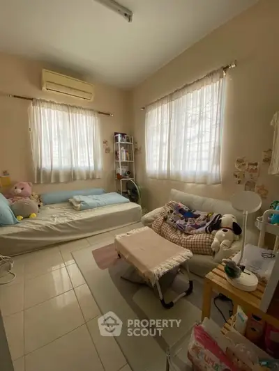 Cozy bedroom with natural light, featuring a comfortable bed and stylish decor.