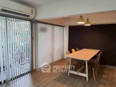 Modern dining area with wooden flooring and stylish pendant lights in a cozy apartment.