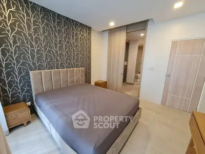 Modern bedroom with stylish wallpaper and cozy bed in a contemporary apartment.