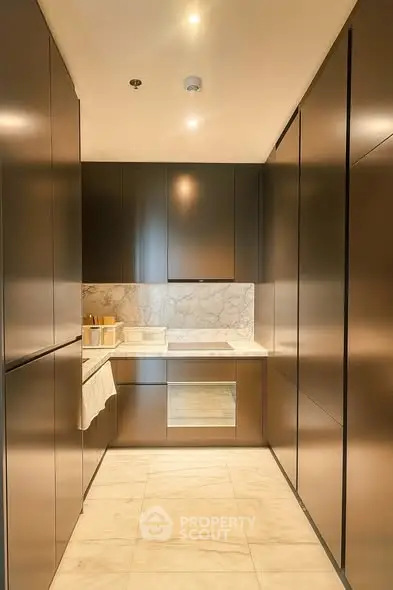 Sleek modern kitchen with marble backsplash and integrated appliances