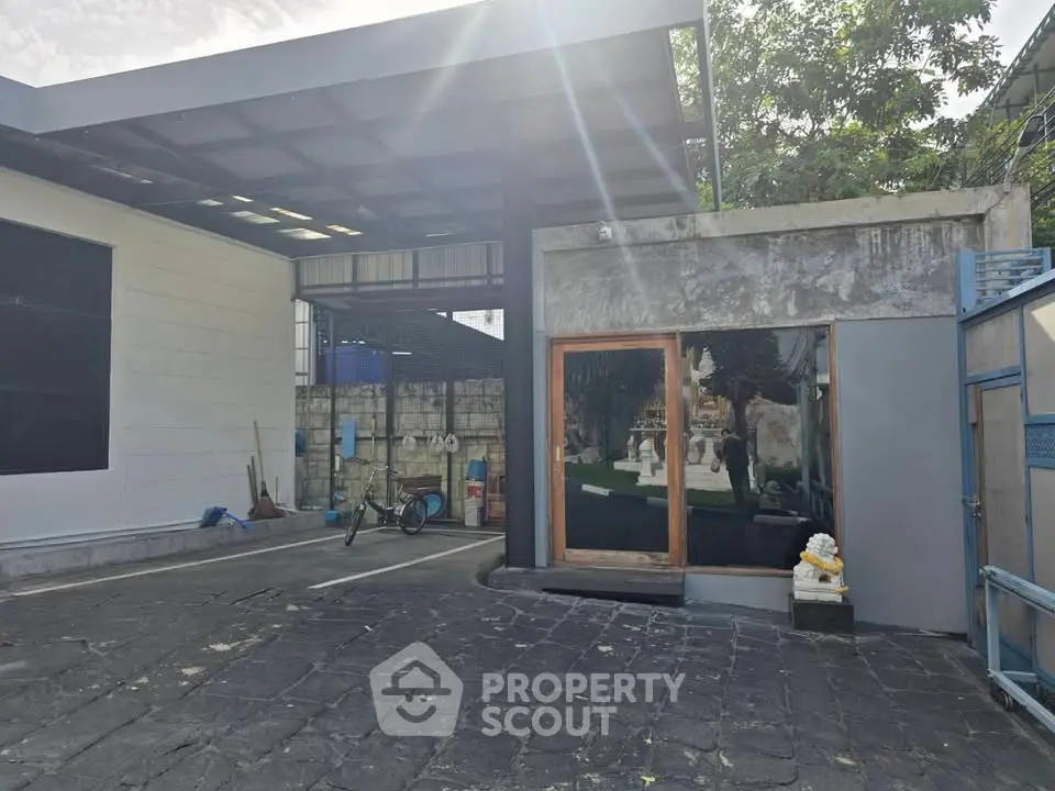 Modern industrial exterior with spacious parking and unique architectural design.