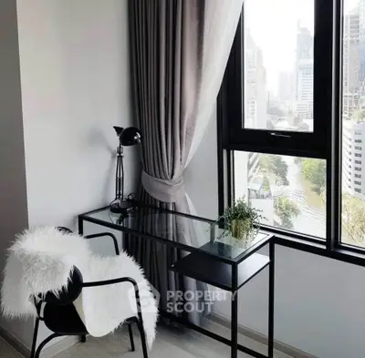 Chic study nook with city view, featuring a sleek glass desk and cozy chair, perfect for urban living.