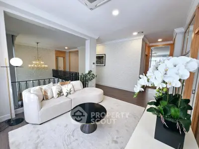 Elegant living room with plush white sofa, modern decor, and stylish lighting in a luxurious home.