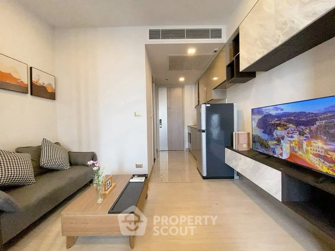 Modern living room with sleek furniture and wall-mounted TV in a stylish apartment.