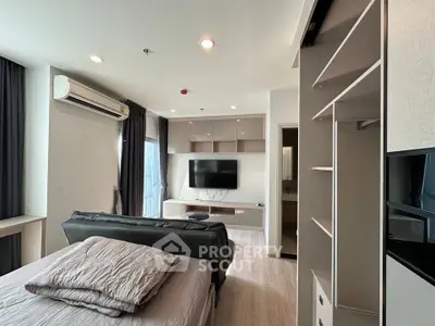 Modern studio apartment with sleek design, featuring a cozy bed, wall-mounted TV, and ample storage space.