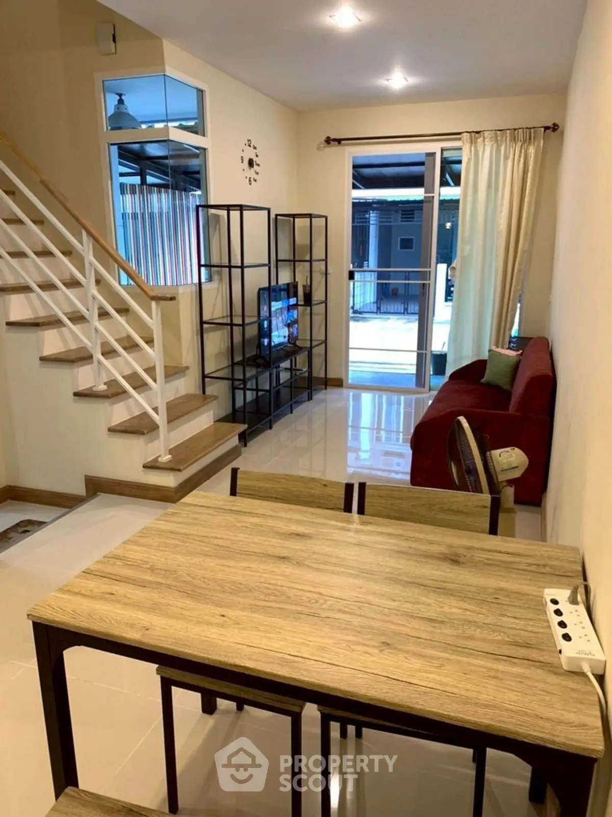 Modern living room with staircase and dining area in cozy home