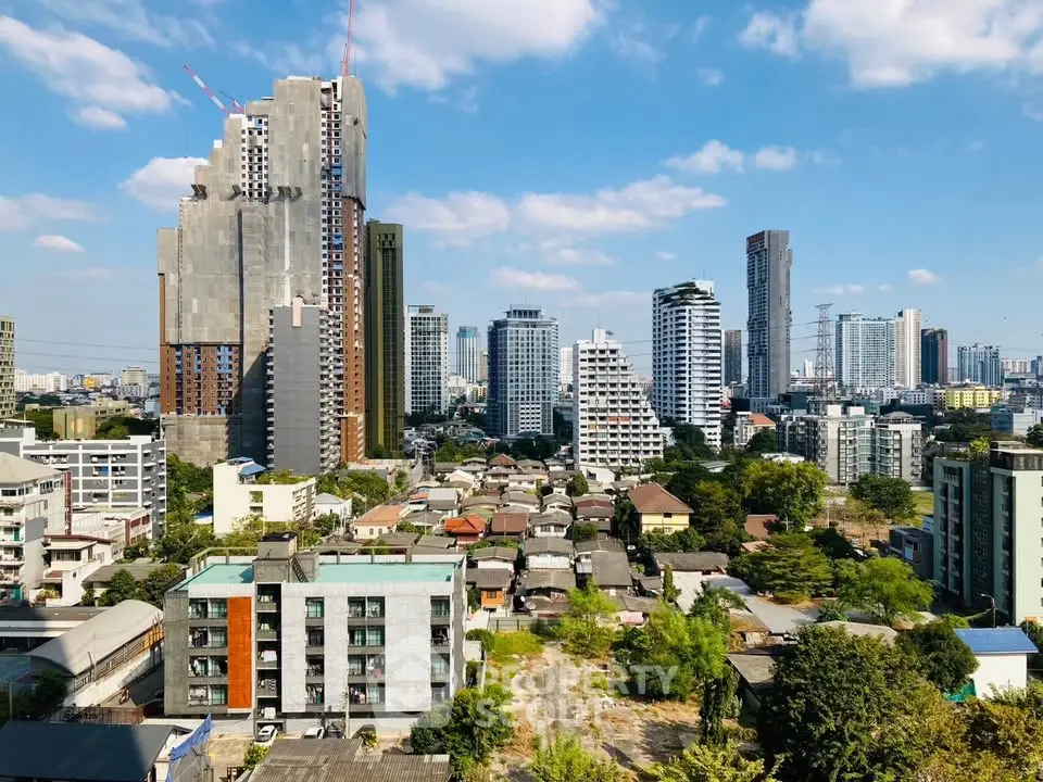 Stunning cityscape view showcasing modern high-rise buildings and lush greenery under a clear blue sky.