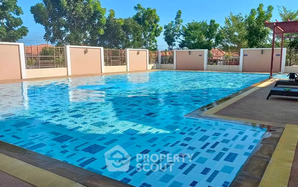 Stunning outdoor pool area with clear blue water and lush greenery, perfect for relaxation and leisure.