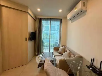 Modern living room with cozy sofa, glass table, and balcony view in a stylish apartment.