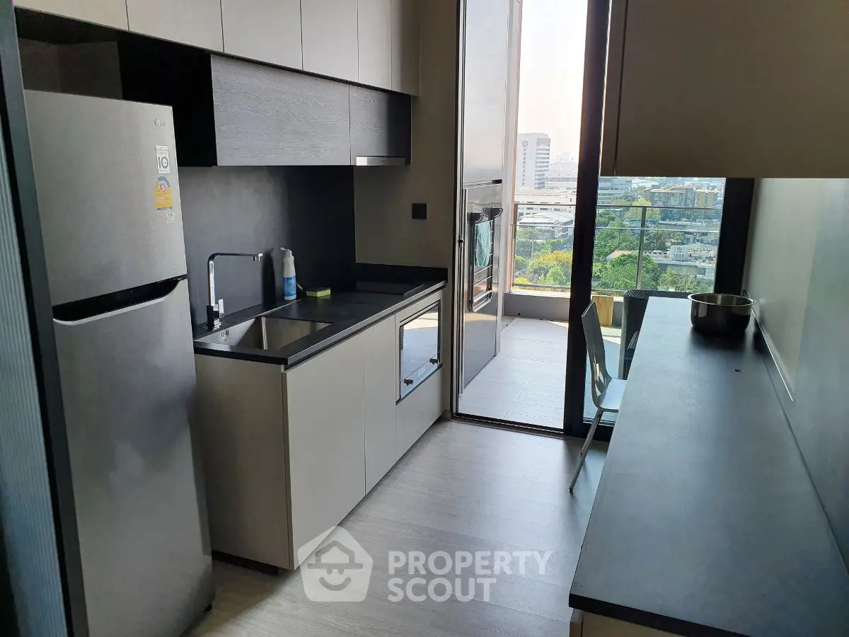 Modern kitchen with sleek cabinetry and balcony view in urban apartment
