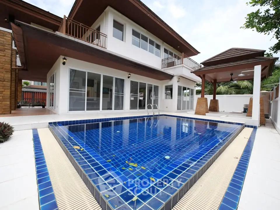 Luxurious modern villa with private blue-tiled swimming pool and spacious outdoor area.