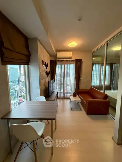 Modern living room with city view, featuring stylish furniture and large windows for natural light.
