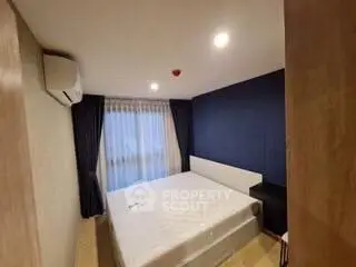 Cozy bedroom with modern decor and large window for natural light.