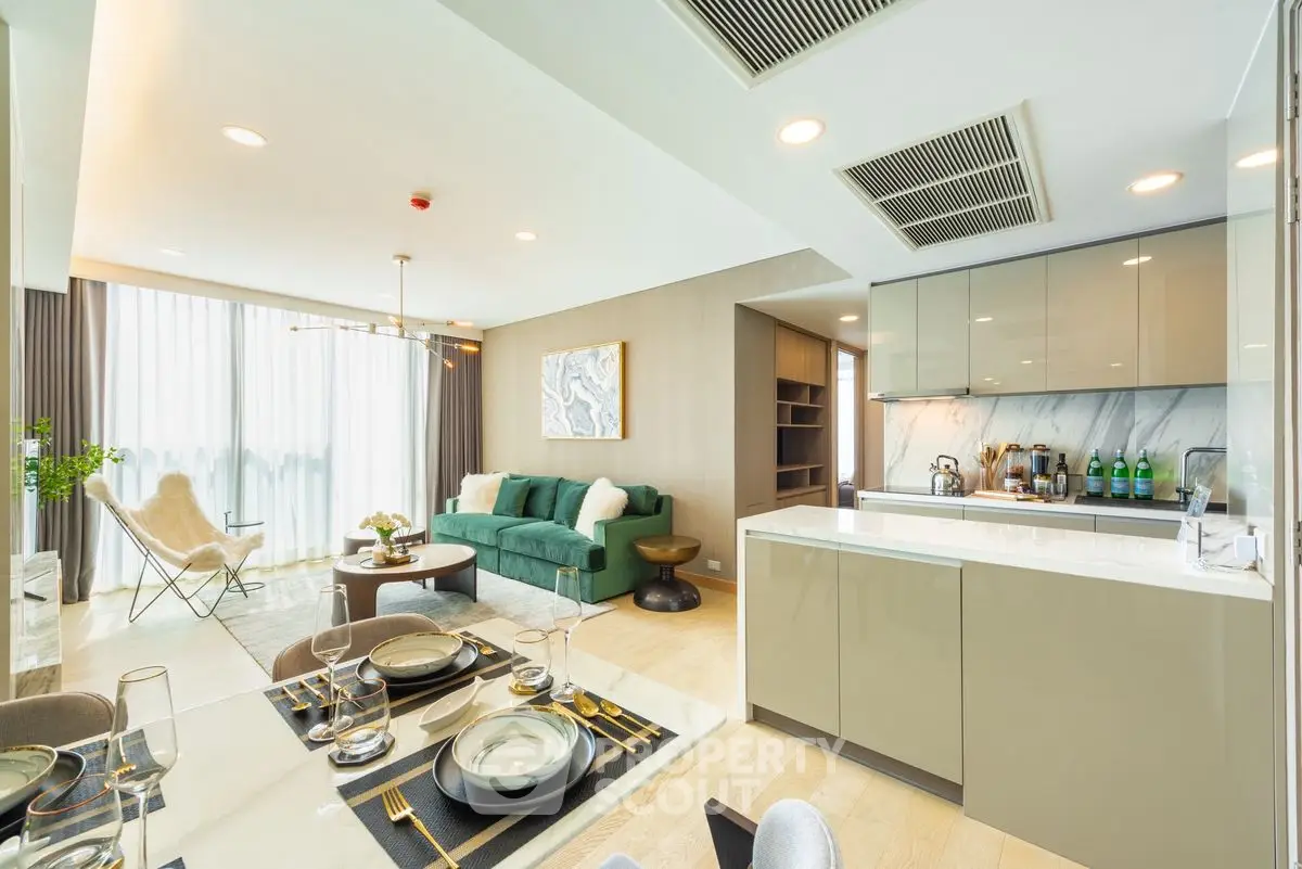Luxurious open-plan living room and kitchen with modern decor and ample natural light.