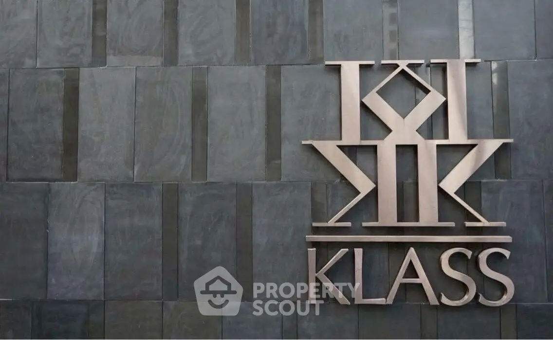 Modern building facade with stylish Klass logo on sleek stone tiles.