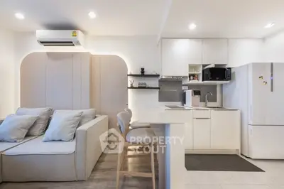 Modern open-layout kitchen and living room with sleek design and cozy seating area.