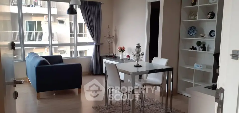 Modern living room with dining area and large windows in a stylish apartment.