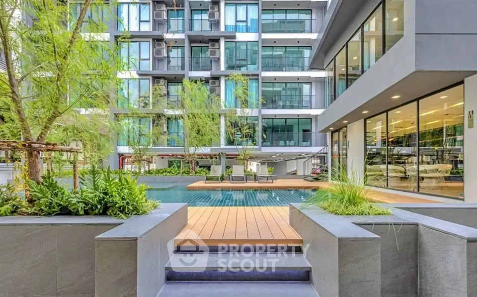 Modern apartment complex with pool and lush greenery, offering a luxurious lifestyle.