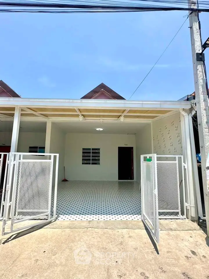 Charming single-story home with gated entrance and spacious front patio, perfect for outdoor activities.