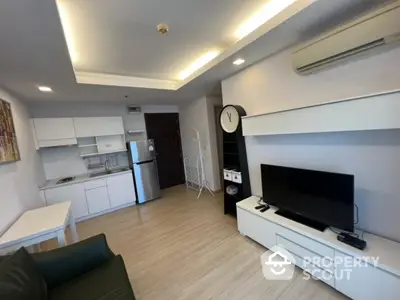 Modern living room with sleek kitchen and stylish decor in open layout apartment.