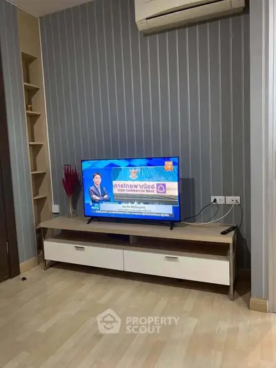 Modern living room with stylish TV setup and air conditioning, perfect for relaxation.
