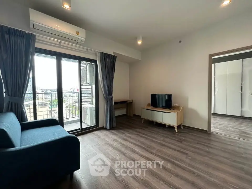 Spacious modern living room with balcony view and sleek wooden flooring.